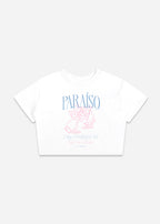 White crop top with a graphic design. The design features the word 'PARAISO' in light blue, above an illustration of two hands toasting martini glasses in pink. Below the illustration, the text reads 'Day Drinking Club Girls 2-4-1 all day!' in light blue.